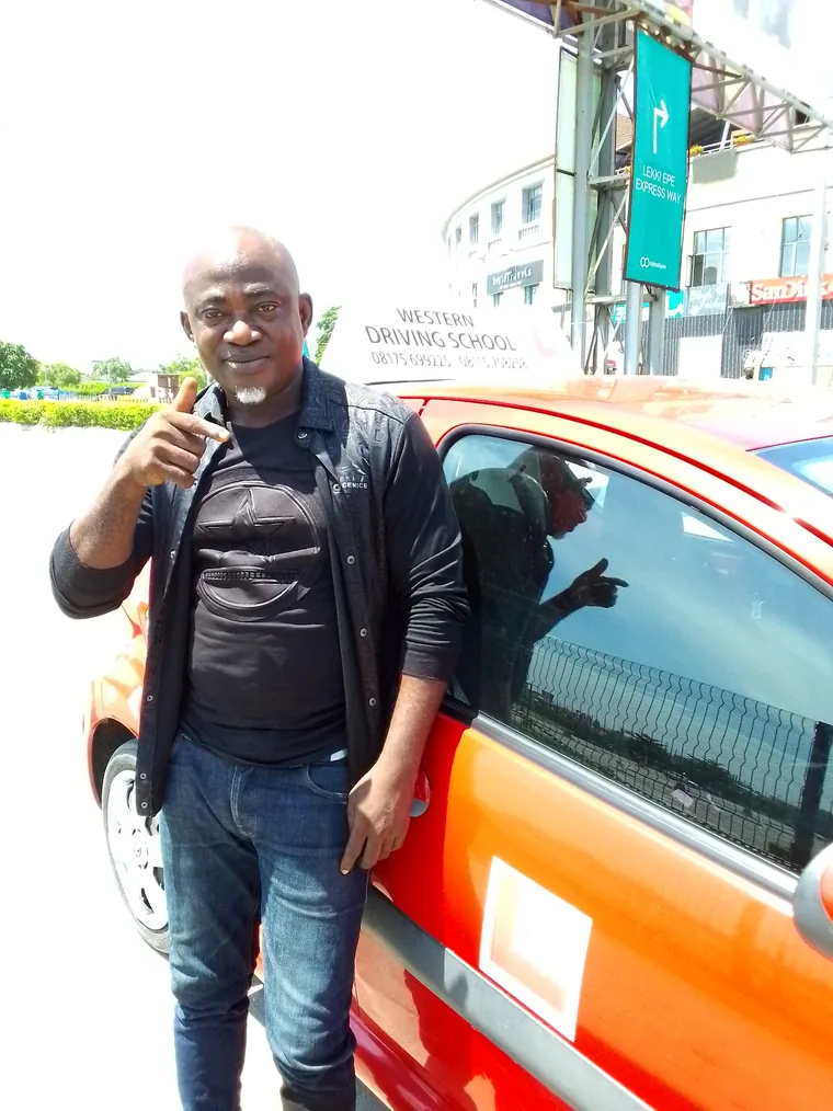 Proud WDS student beside a training vehicle